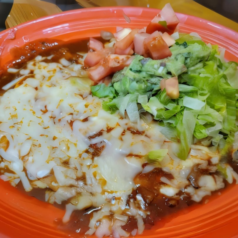 El Rodeo's Mexican dish with melted cheese, red sauce, guacamole, shredded lettuce, and diced tomatoes.